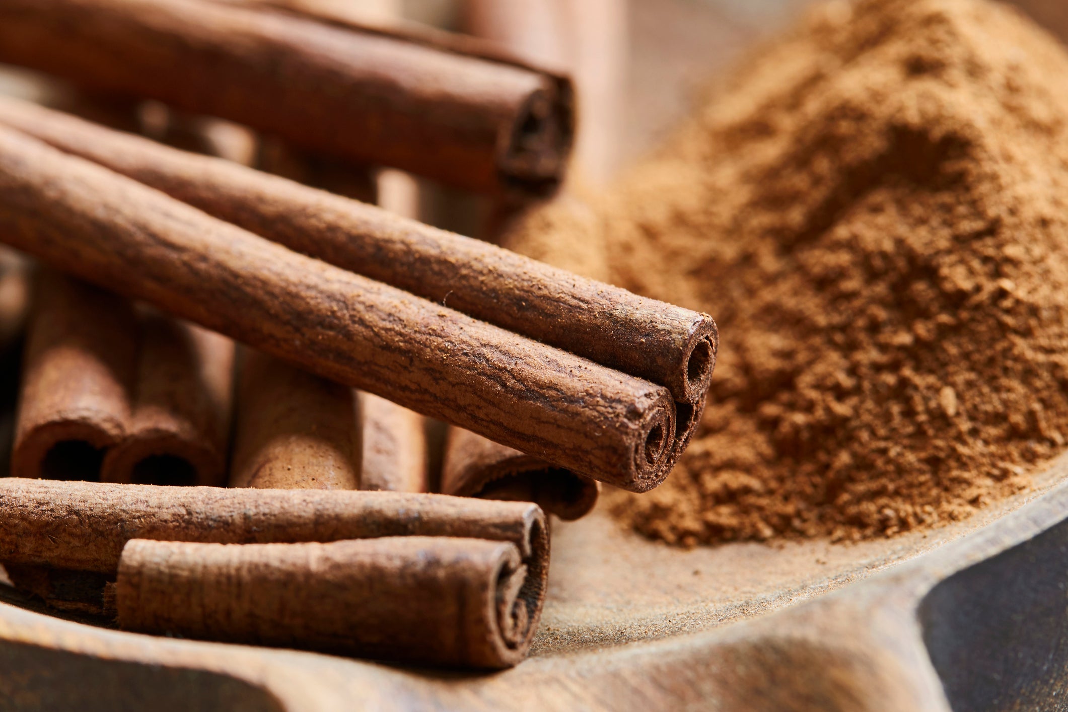 Cinnamon sticks and ground cinnamon on a wooden surface