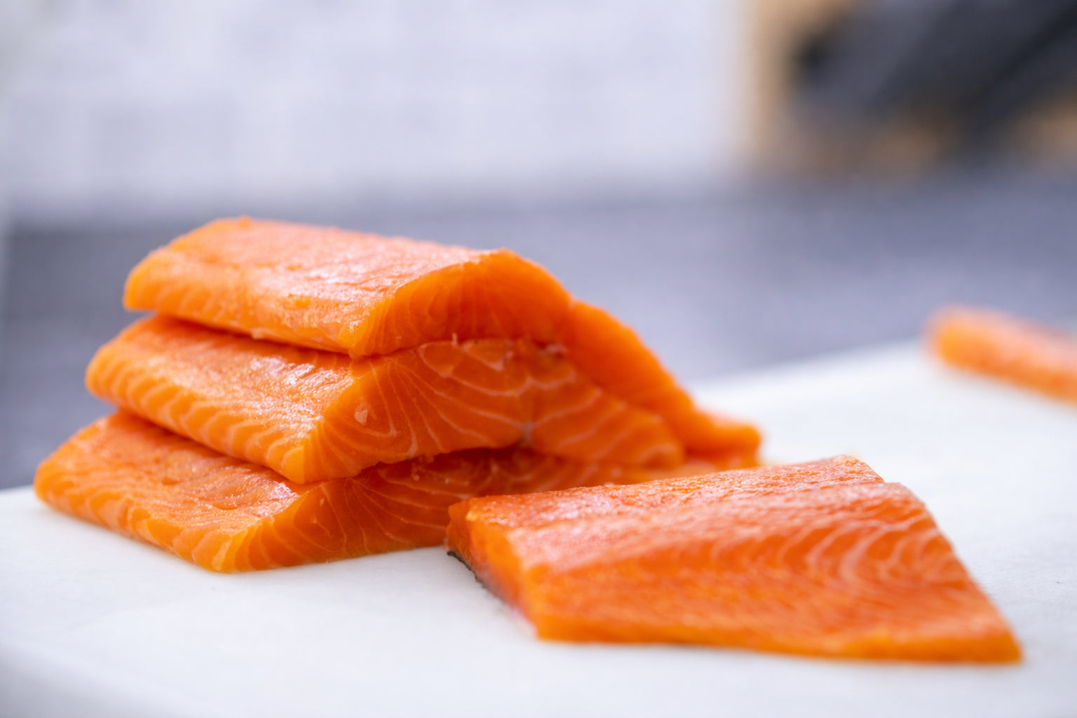 Salmon fillets on a cutting board with a blurred background