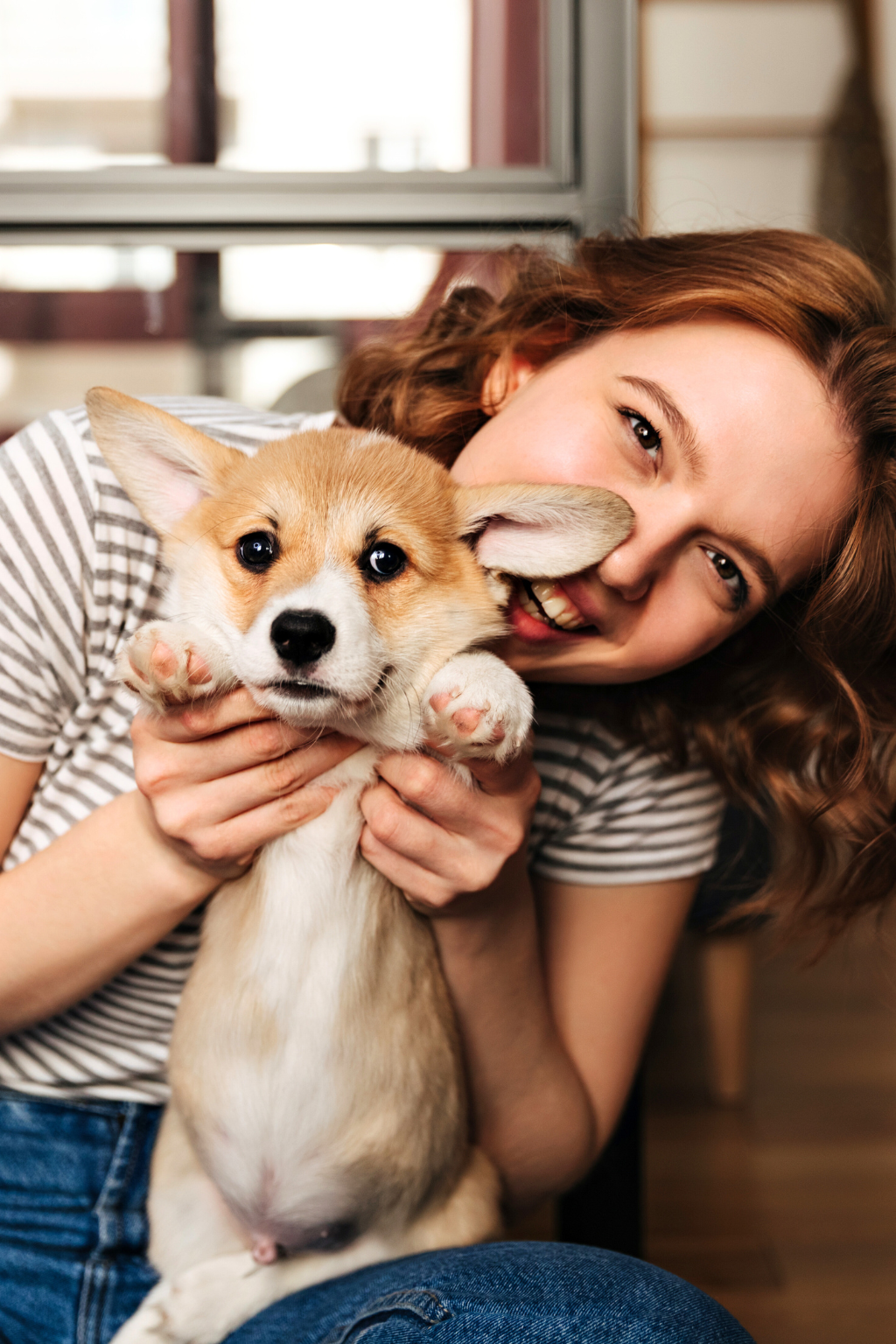 Woman holding a small dog in a home setting